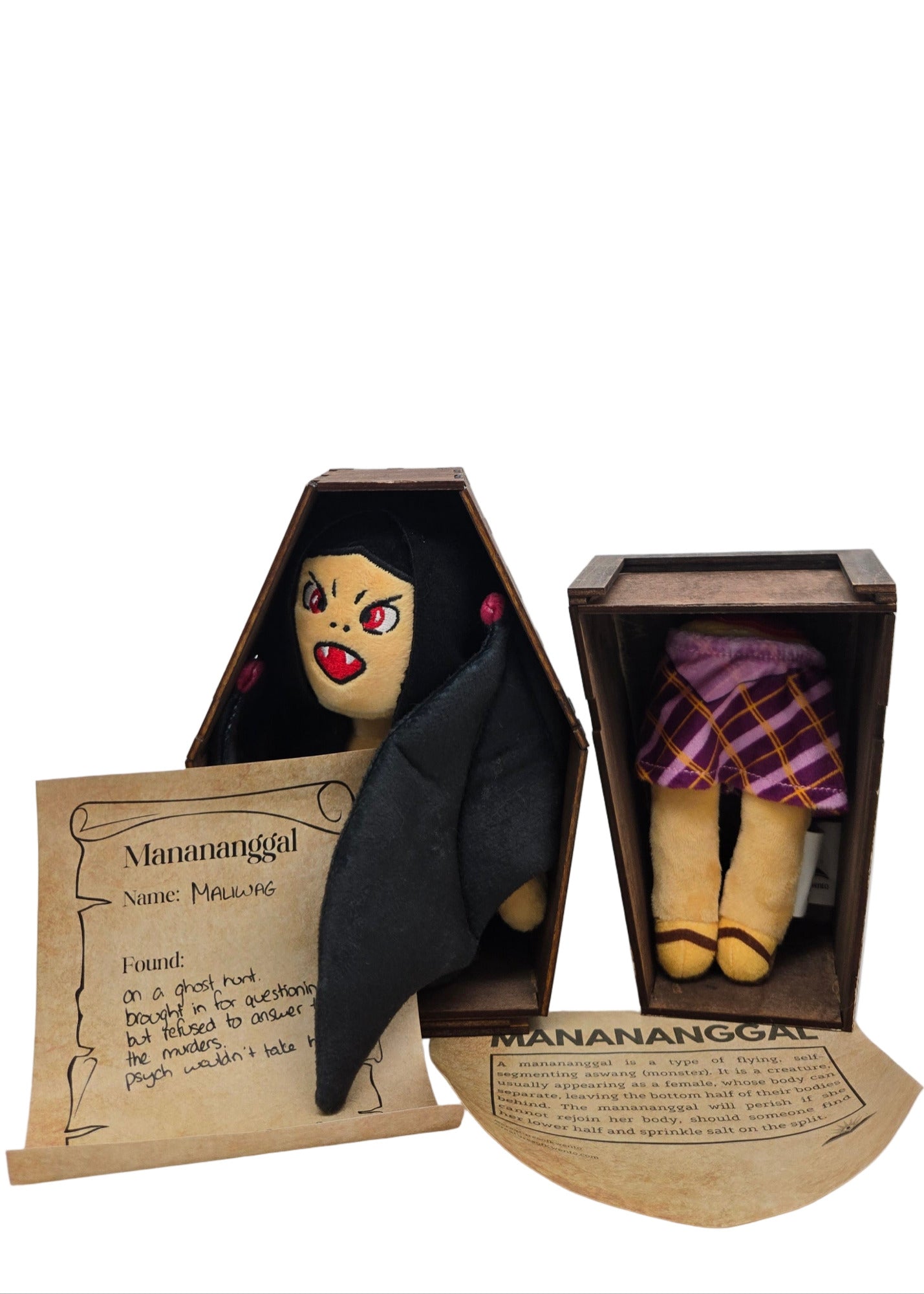 Small doll with black hair and red eyes in a wooden coffin on a white background