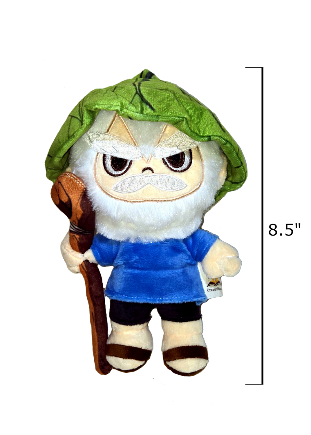 Plush toy with green leaf hat and blue shirt, holding a stick, on a white background with measurement label.