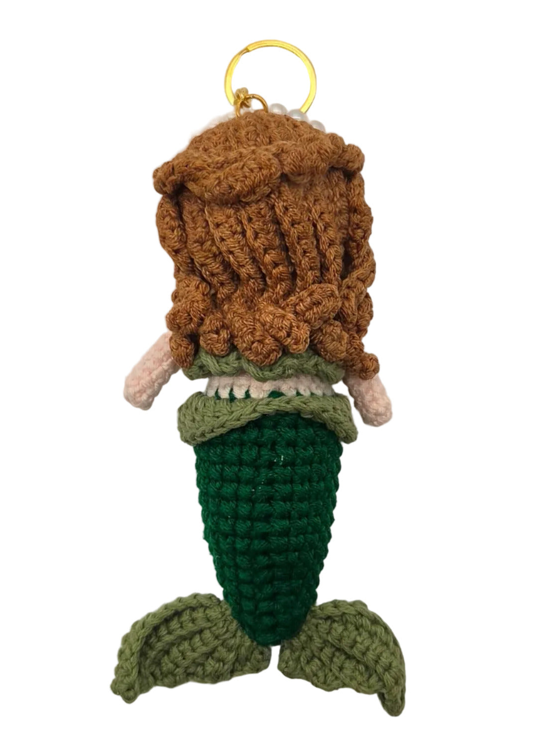 The back of a small crocheted mermaid keychain with brown hair, a green tail, and a gold key ring, shown on a plain white surface.