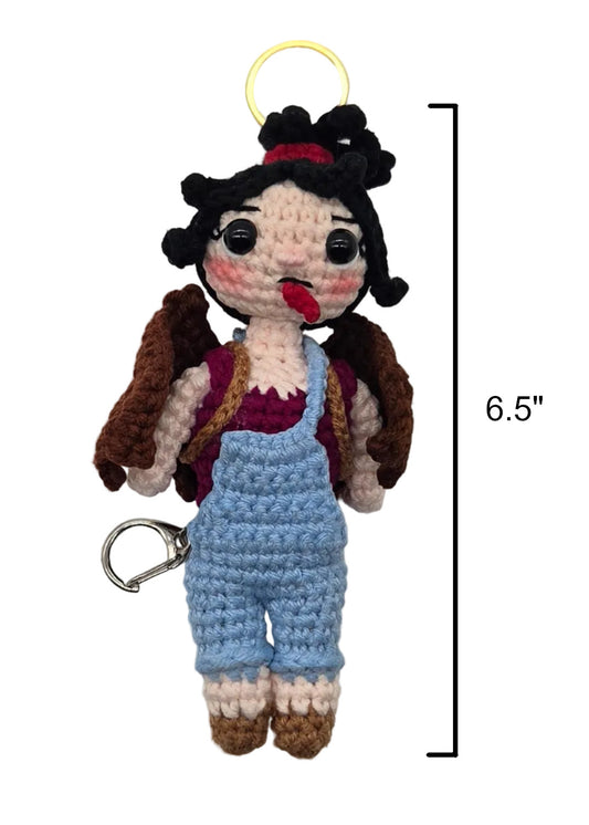 A crocheted keychain doll with black hair, a red top, and light blue overalls, shown on a white background with a height measurement marker of 6.5 inches.