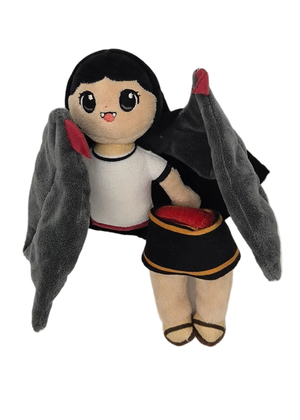 A small plush with black hair, a white top, a black skirt, and gray wings, photographed against a plain light background.