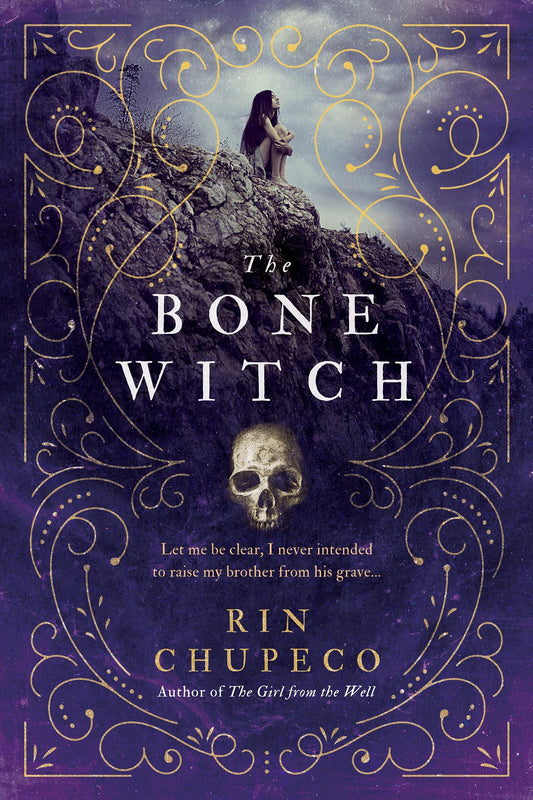 Book cover of 'The Bone Witch' with a woman on a rocky outcrop and decorative gold text.