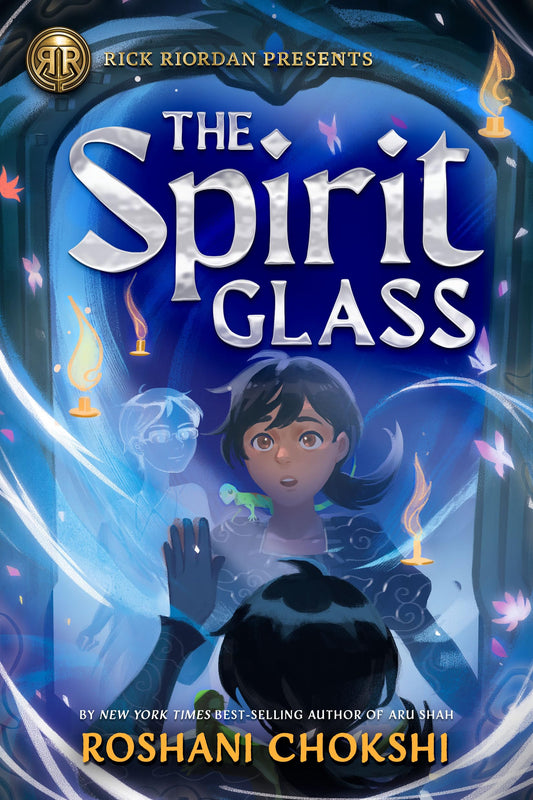 Book cover of 'The Spirit Glass' by Roshani Chokshi with a blue and purple color scheme. A girl is looking in a mirror and appears to see a ghost.