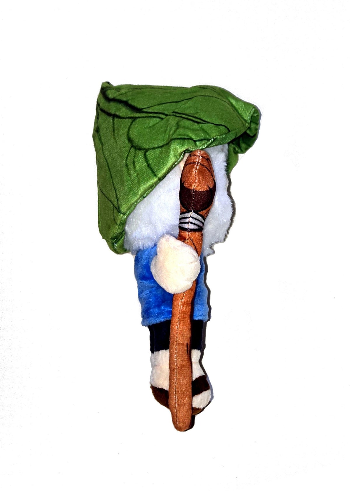 Right side view of the dwende plush. It shows the green hat that looks like a leaf is cone-shaped. In his right hand, he is holding what looks like a wood cane.