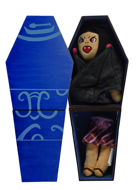 Toy doll with red eyes and black hair in a blue coffin