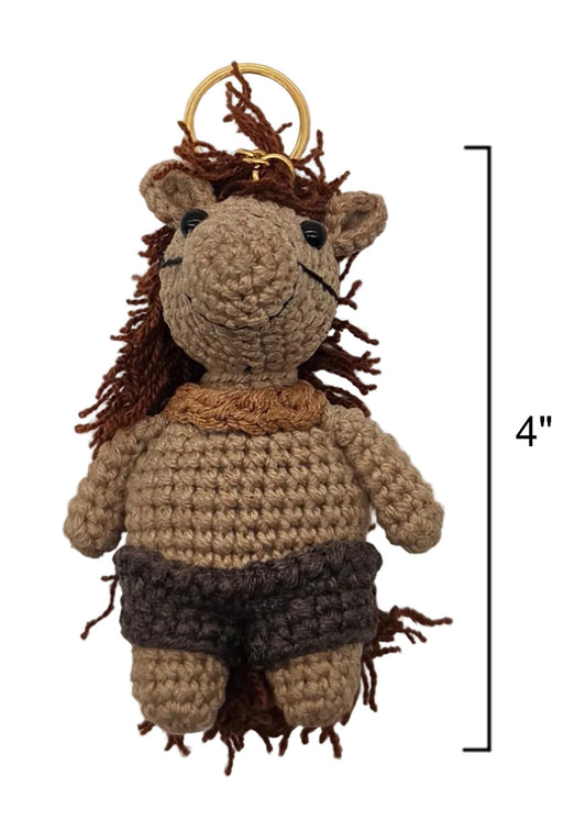 A crocheted plush half-horse/half-human keychain in beige and brown yarn with a gold metal keyring, shown on a white background with a vertical measurement marker indicating 4 inches.